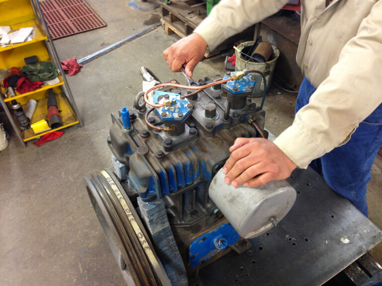 Lubbock Electric technician repairing reciprocating compressor